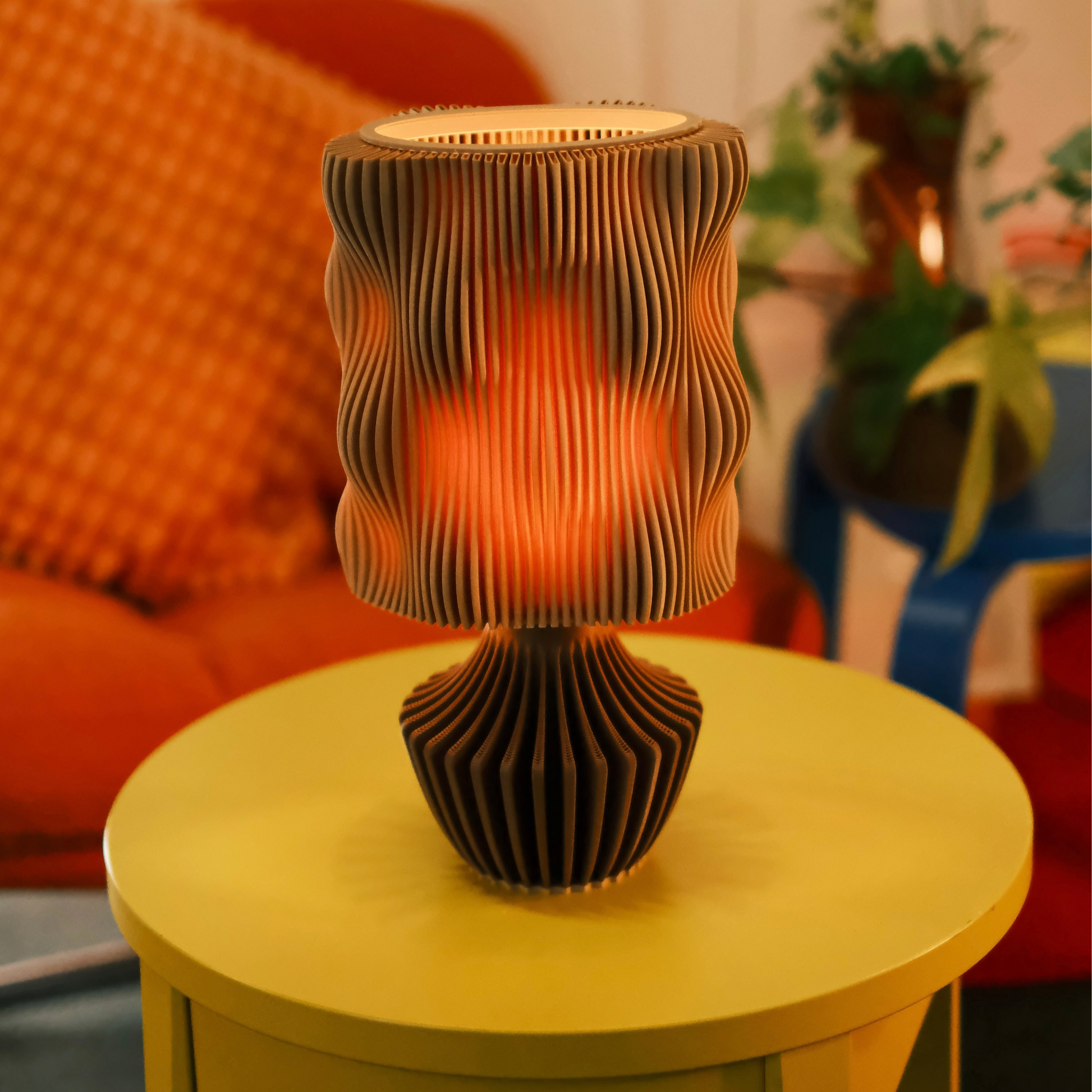 Decorative lamp with wavy design on a yellow table in a cozy room setting.